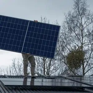 man on roof installing solar panels